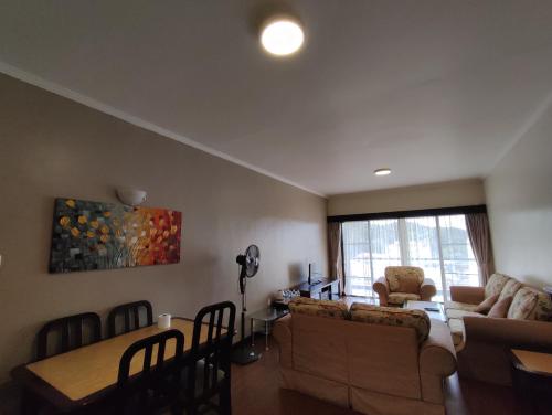 un salon avec un canapé et une table dans l'établissement Awesome Homestay Apartment @ Equatorial Hill Resort, à Brinchang