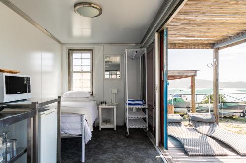 a bedroom with a bed and a view of the ocean at Kite Basecamp Langebaan in Langebaan