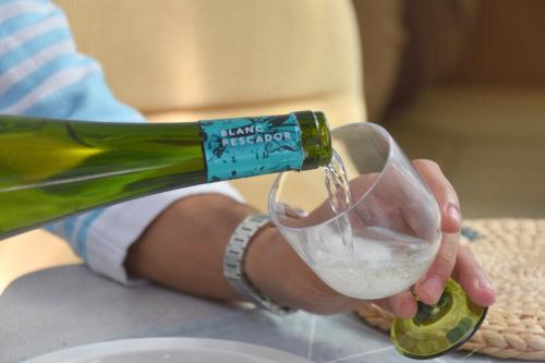 a person pouring a bottle of wine into a wine glass at Luxury Boat KARAMBA I in San Miguel de Abona