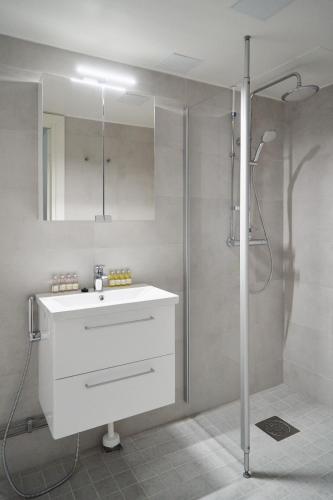 Naantali City Apartments في ناتالي: حمام مع حوض أبيض ودش