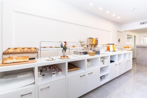 索伦托Hotel Isabella Sorrento的厨房配有白色橱柜和展示食物