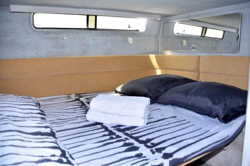 a bed with two pillows and two towels on it at Luxury Boat KARAMBA I in San Miguel de Abona