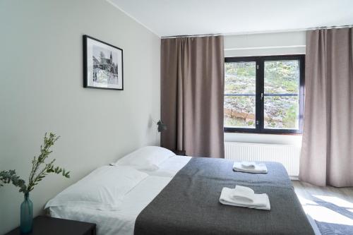 a hotel room with a bed and a window at Naantali City Apartments in Naantali