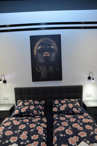 a bedroom with two beds and a picture on the wall at Room Marsonia in Slavonski Brod
