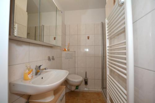 ボルクムにあるBorkum-Vierの白いバスルーム(洗面台、トイレ付)