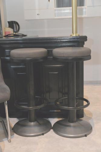 a black bar stool with two stools under a table at Room Marsonia in Slavonski Brod