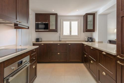 een grote keuken met houten kasten en een raam bij SF Marbella Luxury Beach Apartment - Jardines de las Golondrinas in Marbella