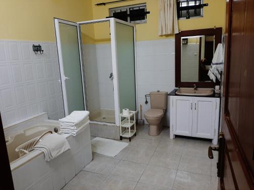 une salle de bain avec une baignoire, des toilettes et un lavabo dans l'établissement DINO1, à Trou aux Biches