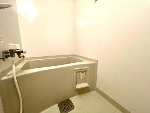 a bathroom with a bath tub with a hose at 2-2札幌駅徒歩7分の好立地Service Apartment SAPPORO札幌ステーション綺麗な部屋 in Kita-rokujō
