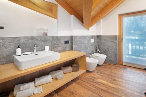 uma casa de banho com um lavatório e um WC em Olympic Chalet 13 em Bormio