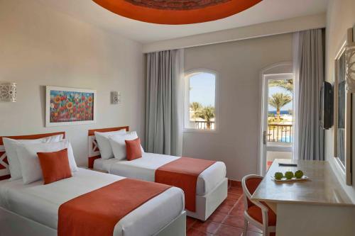 a hotel room with two beds and a table at Solymar Reef Marsa in Coraya Bay