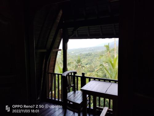 a porch with a table and a view of the mountains at D'kailash Retreat in Singaraja