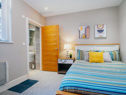 a bedroom with a bed and a wooden door at AVO Kelham Apartments in Sheffield