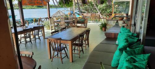 um restaurante com mesas e cadeiras e vista para a água em Pousada Carapeba em São Francisco