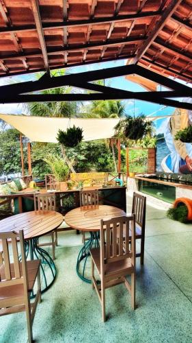 a patio with wooden tables and chairs under an umbrella at Pousada Carapeba in São Francisco