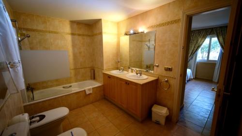 a bathroom with a sink and a tub and a toilet at Marbella Beach Resort at Club Playa Real in Marbella
