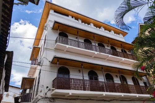 - un bâtiment avec balcon dans une rue dans l'établissement Aurelia Zanzibar, à Ngambo