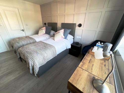 a bedroom with two beds and a desk with a computer at United Home B&B in Manchester