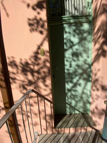 a glass door on a stairs with a shadow of a tree at Locanda La Cavallina in Brisighella