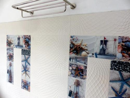 a room with a white wall with pictures on it at Villa la Perle, piscine privée, vue sur le lagon in Mahébourg