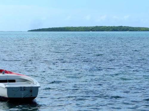 a white boat in the middle of a large body of water at Villa la Perle, piscine privée, vue sur le lagon in Mahébourg