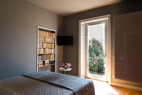 1 dormitorio con cama y estante de libros con ventana en Villa delle Fiabe - Homelike Villas, en Ossuccio