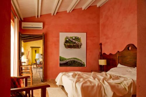 una camera da letto con un letto e una parete arancione di Villa delle Palme - Homelike Villas a Castelvetrano Selinunte