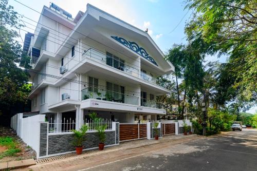 a white building with a blue sign on it at Lotus & Orchid Villas by Ramnath Homes in Sangolda