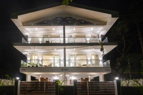 a large white building with a balcony at night at Lotus & Orchid Villas by Ramnath Homes in Sangolda