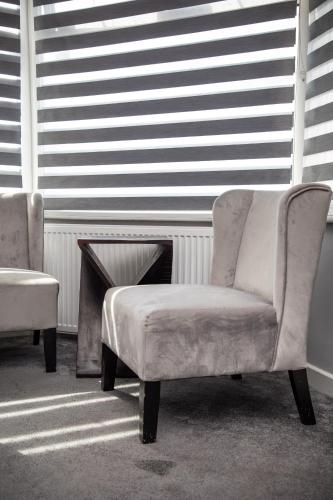 a living room with a chair and a table at King Solomon Hotel- Golders Green in London