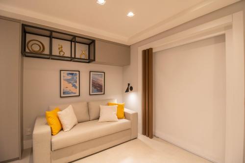 a living room with a couch with yellow pillows at Unique Studio - GRU 1803 in Guarulhos