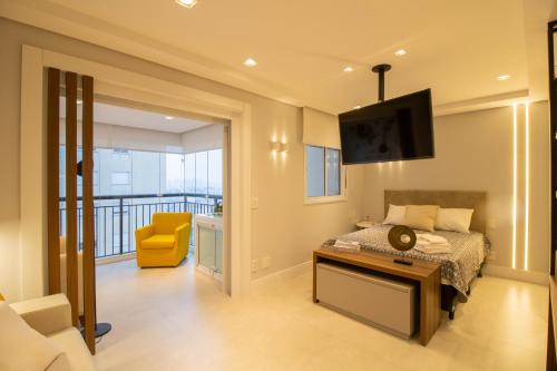 a bedroom with a bed and a tv and a balcony at Unique Studio - GRU 1803 in Guarulhos