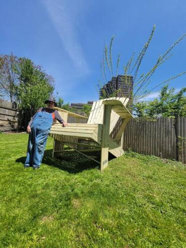 a man standing next to a wooden bench in a yard at 2 BR - Off Street Parking - Amazing View Nearby in Pittsburgh