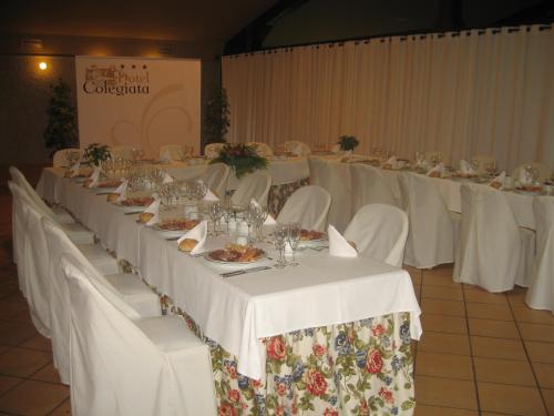 a long table with white tables and white chairs at Hotel Colegiata in Santillana del Mar