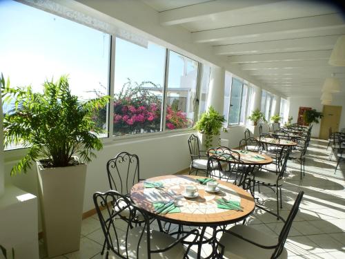 a row of tables and chairs in a room with windows at Hotel Ossidiana Stromboli Center in Stromboli