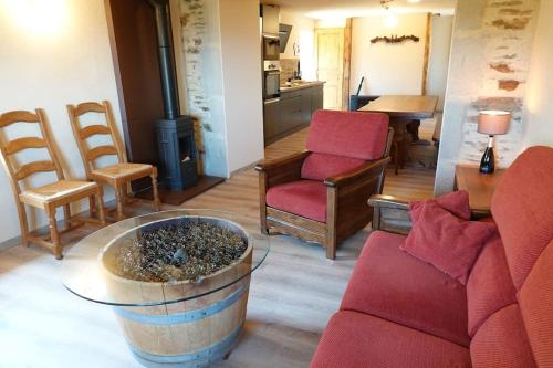 a living room with a couch and chairs and a table at Les Combres, gîte nature avec piscine in Malbosc