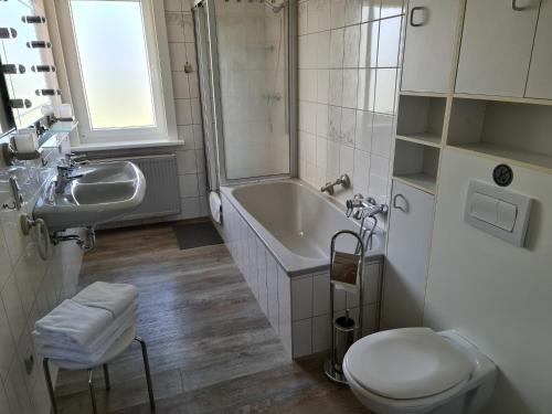 ein Badezimmer mit einer Badewanne, einem WC und einem Waschbecken in der Unterkunft EderseeGlück - Fewo 1 in Bringhausen