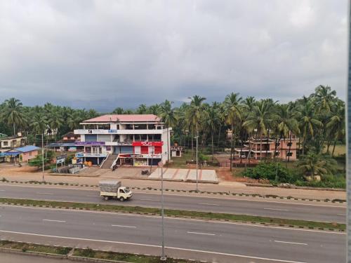 a truck driving down a road in front of a building at Hotel Mother Palace - Blue Rays in Baindūru