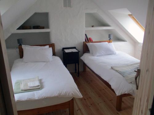 The Workshop- Eco Cottage by the Coastal Path tesisinde bir odada yatak veya yataklar