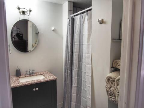 a bathroom with a shower and a sink and a mirror at The Bissing House in Hays