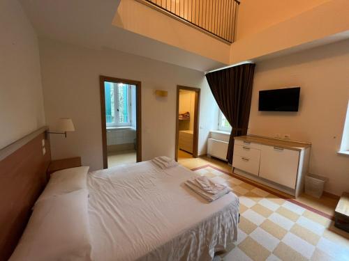 a bedroom with a white bed and a television at Domus Stella Maris - Casa per Ferie in Ancona