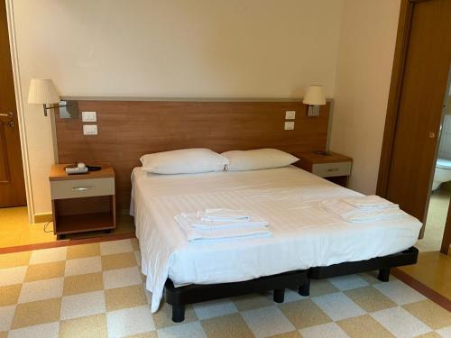 a bedroom with a bed with white sheets and pillows at Domus Stella Maris - Casa per Ferie in Ancona