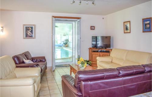 un salon avec deux canapés et une télévision dans l'établissement Stunning Home In Yvias With Sauna, à Yvias