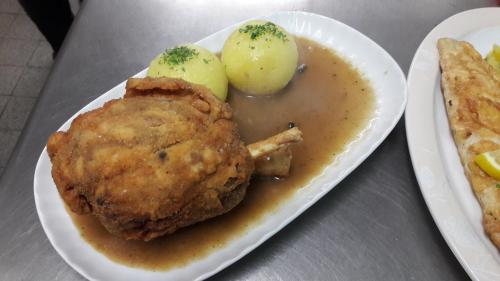 a plate of food with meat and potatoes on a table at Verwöhn-Pension Wiesengrund in Bischofsgrün