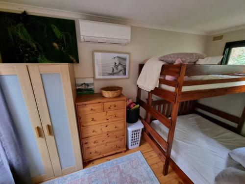 a bedroom with two bunk beds and a dresser at Cozy Beachcomber @Smith's Beach in Smiths Beach