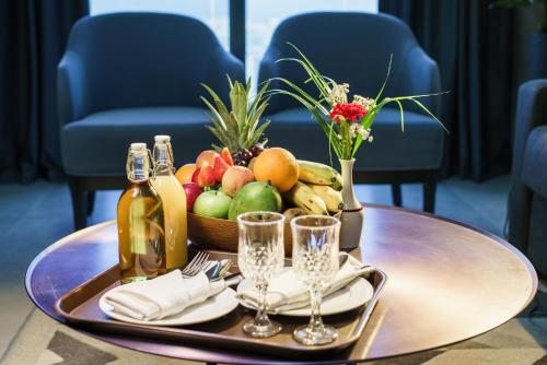 a tray of fruit and champagne on a table at Hotel Holiday International in Sharjah