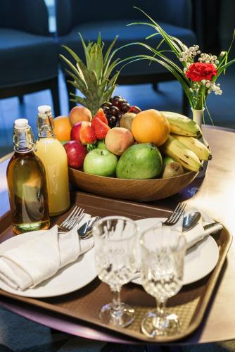 a tray with a bowl of fruit on a table at Hotel Holiday International in Sharjah