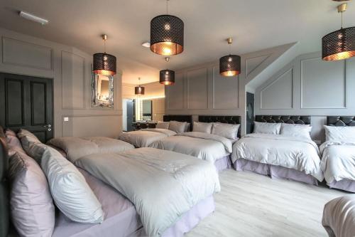 um quarto com um monte de camas brancas em Manhattan Suite - sleeps 24! Heart of Liverpool em Liverpool