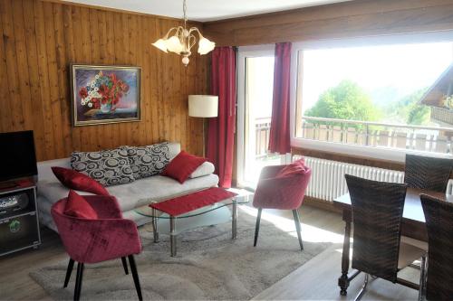 ein Wohnzimmer mit einem Sofa, Stühlen und einem Fenster in der Unterkunft Magrappé MOUNTAIN & CENTER apartments in Veysonnaz