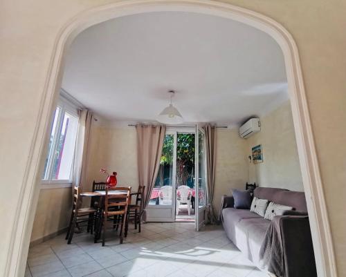- un salon avec une table, un canapé et un miroir dans l'établissement La Maryse de Cassis, à Cassis